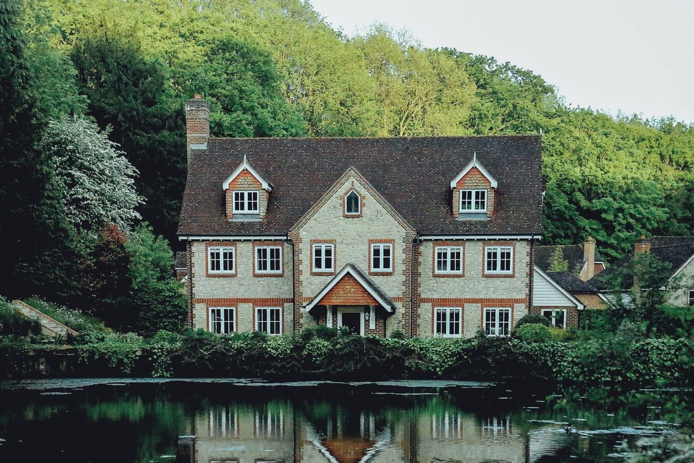 A large house with a pond in front of it Description automatically generated with low confidence