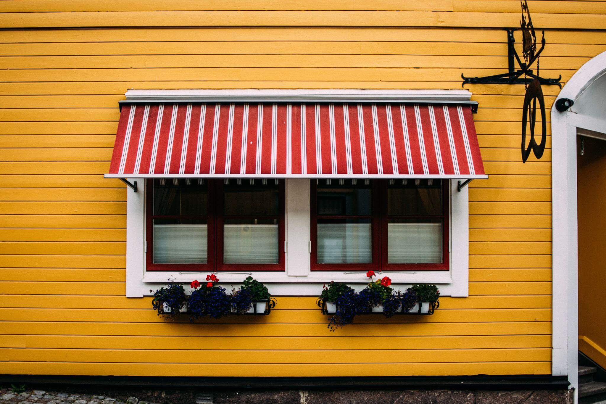 A white and red stripe awning with a yellow wall background