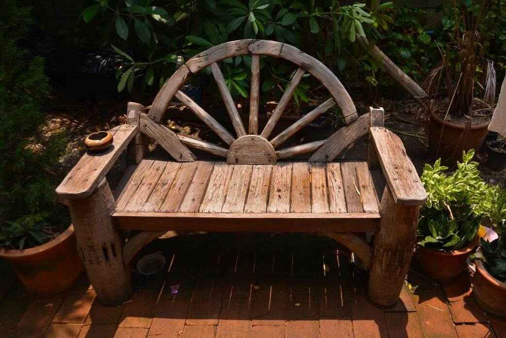 A wooden bench in a garden Description automatically generated with low confidence