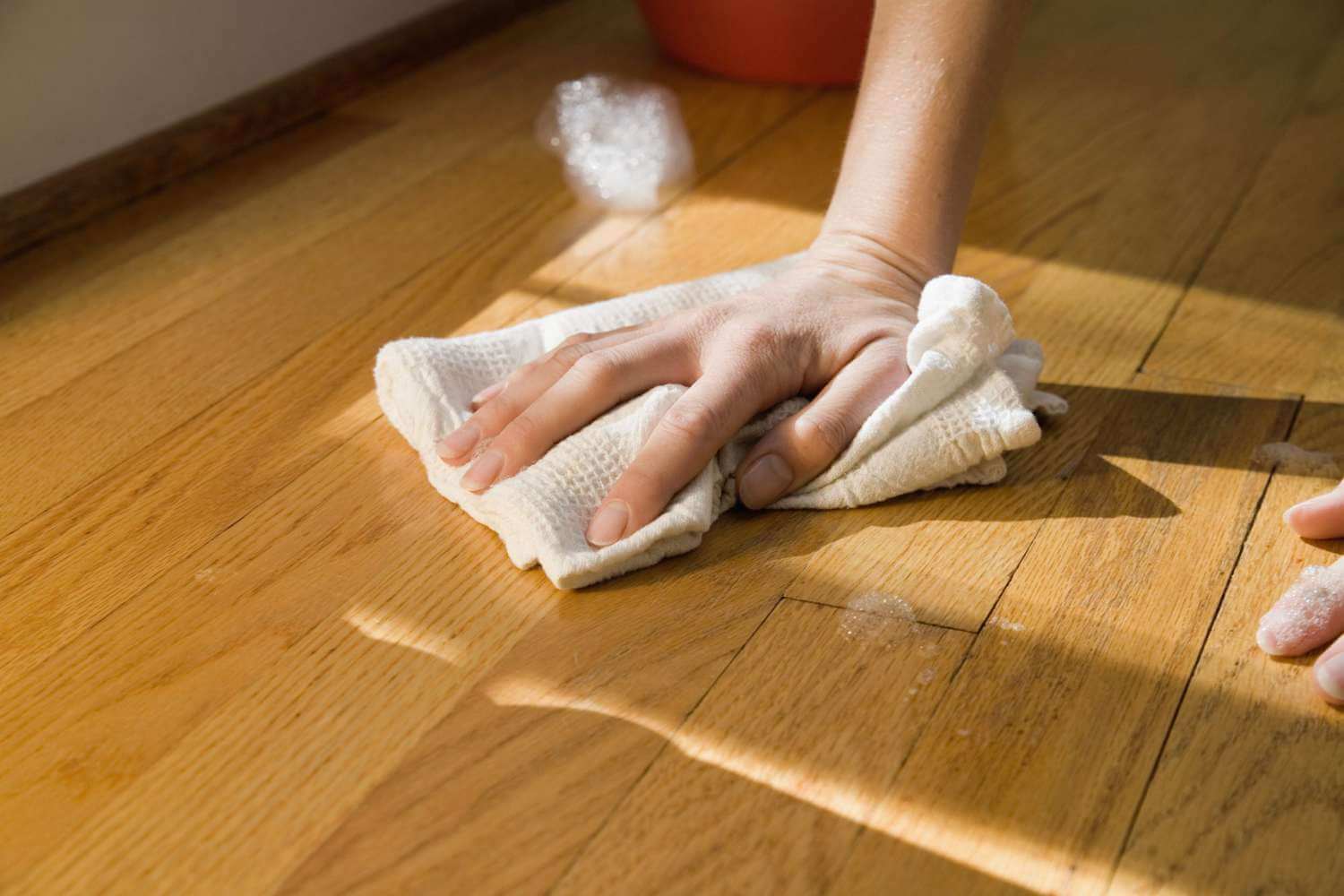 Clean and maintain your wooden floor with a cloth for a shiny finish