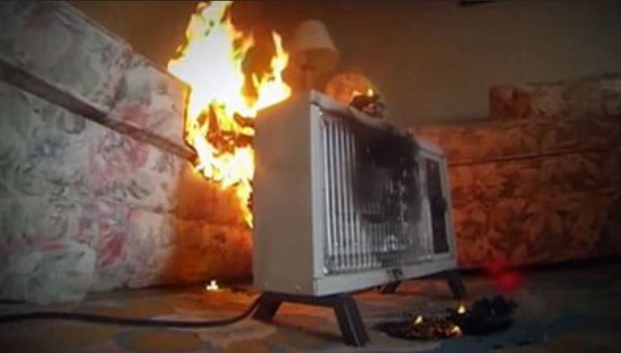 Fire burning in room with heater - caution: dangers of oil-filled heaters.