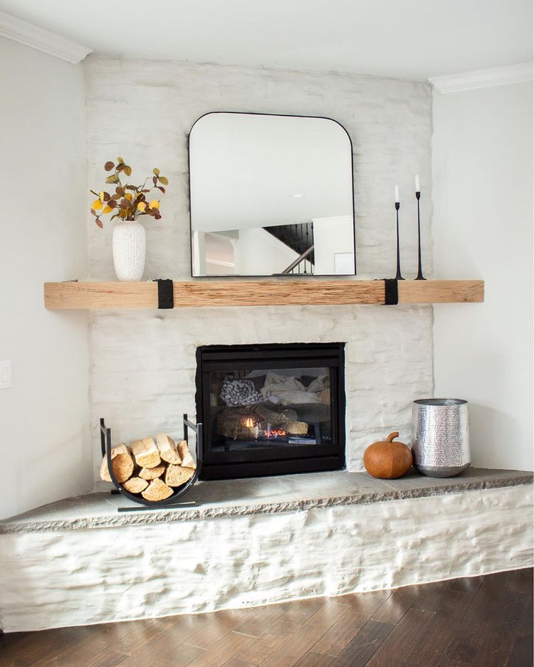 Beautifully finished white fireplace complemented by a mirror