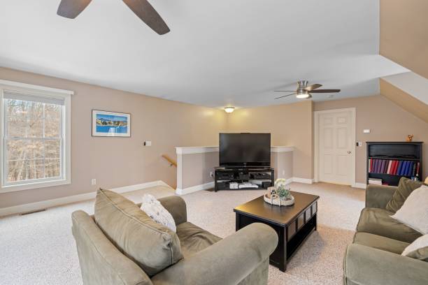 A cozy living room with a ceiling fan and a television, providing comfort and relaxation. Good for Your Back and Neck.