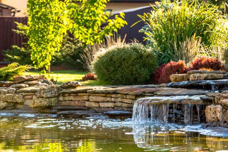 A serene pond with a cascading waterfall surrounded by rocks. Perfect for landscaping