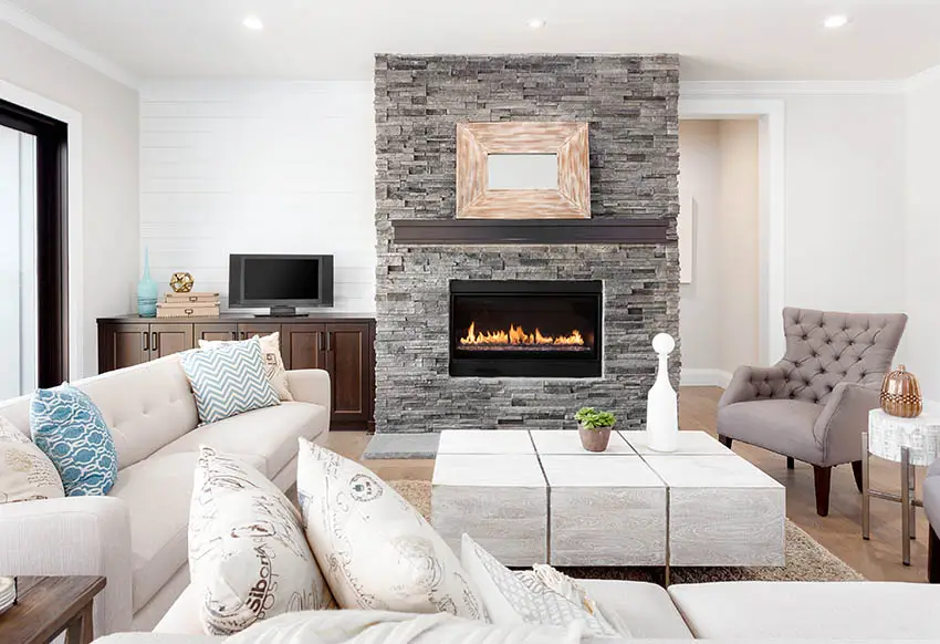 Stone fireplace and white furniture in a cozy living room