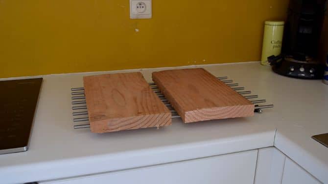 Two wooden boards on a counter top, waiting to dry.