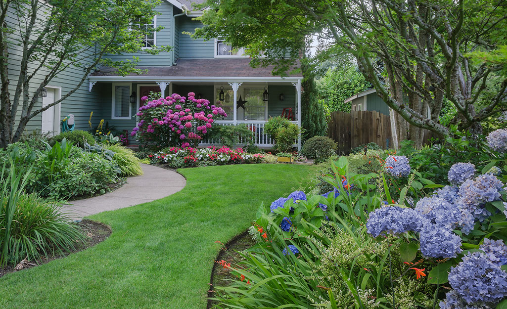 Lush garden filled with colorful flowers and a neatly paved walkway