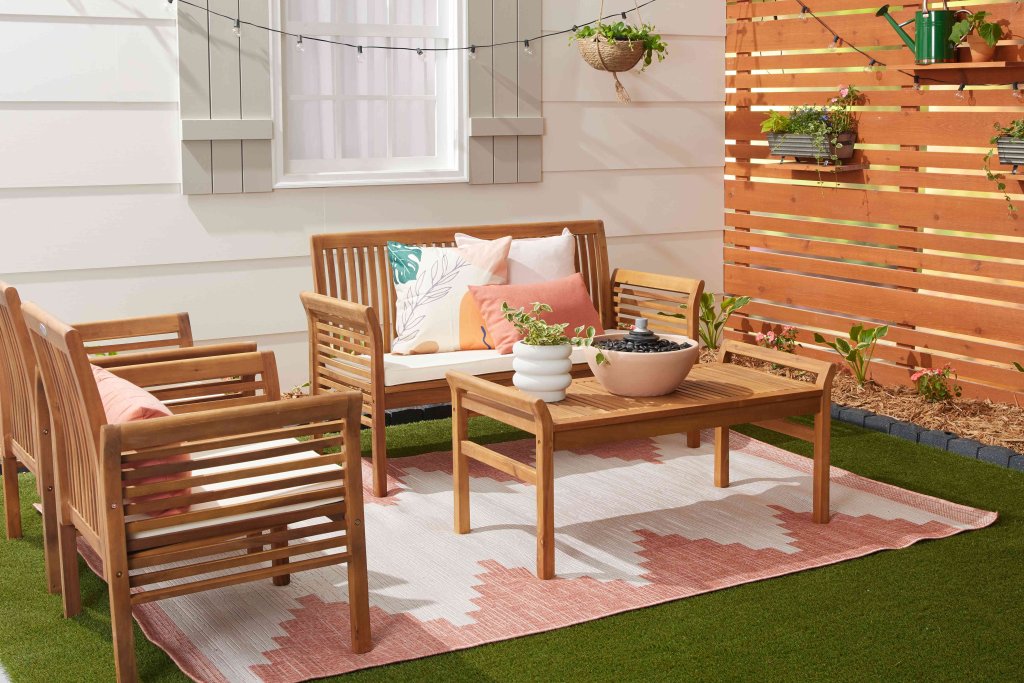 Acacia wood patio set surrounded by vibrant plants