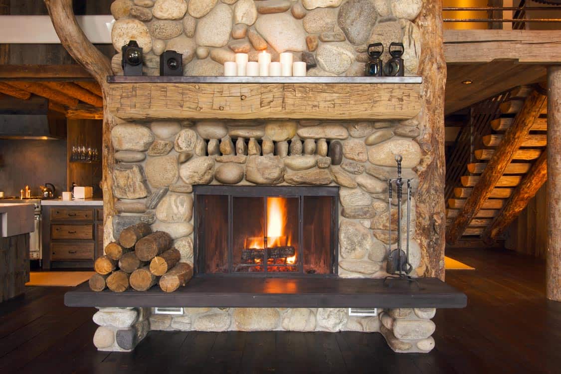 Cozy fireplace with stone mantle and logs, providing warmth and ambiance