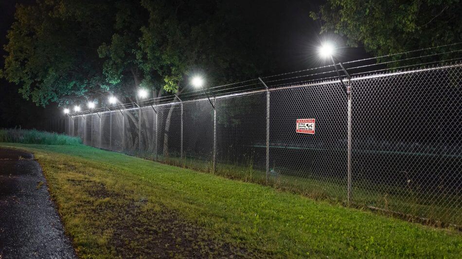  A fence with motion-activated lights or alarms installed, providing enhanced security at night