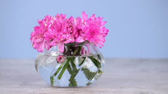 a flower vase with pink flowers in it