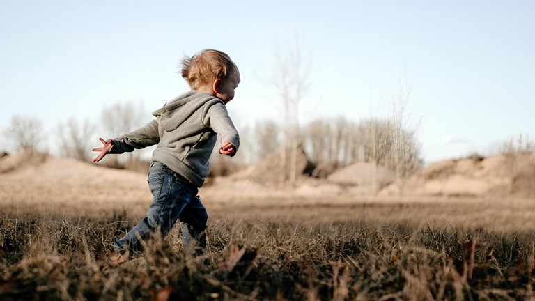 a toddler running in a field